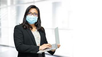 asiatische Dame mit Maske im Amt zum Schutz des Coronavirus.