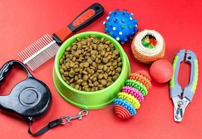 Tiernahrung in Schalen, Spielzeug, für Haustiere auf rotem Grund foto