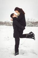 Kerl und ein Mädchen in Kleidung und Schals auf einem Spaziergang im verschneiten Wetter foto