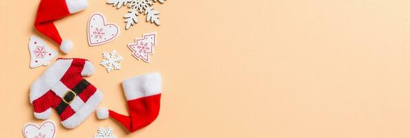oben Aussicht von Banner Weihnachten Dekorationen und Santa Hüte auf Orange Hintergrund. glücklich Urlaub Konzept mit Kopieren Raum foto