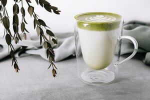 Glas von heiß Matcha Grün Tee Latté mit Tulpe Muster foto