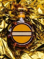 Flasche von Cognac auf golden vereiteln Hintergrund foto