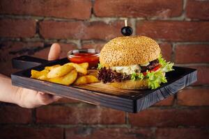 amerikanisch Cheeseburger mit Französisch Fritten auf hölzern Tafel foto