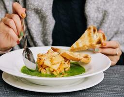 Frau Essen Spinat Suppe mit Meeresfrüchte foto