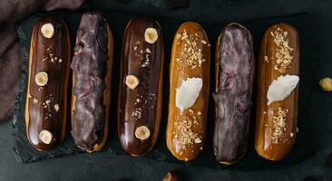 Süss Schokolade Eclairs auf schwarz hölzern Tafel foto