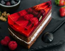 Süss Kuchen mit frisch Beeren und Gelee auf alt Stein Tafel foto