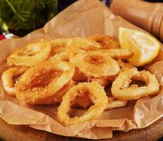 Ofen gebacken paniert Calamari Ringe serviert mit Zitrone foto