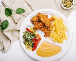 Hähnchen Nuggets mit Französisch Fritten und Senf Soße foto