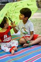 zwei glücklich Jungs im Gesellschaft Park, glücklich asiatisch Brüder Wer sind lächelnd glücklich zusammen. Brüder abspielen draußen im Sommer, Beste Freunde. Kleinkind Baby Junge spielen mit seine glücklich Bruder im das Garten foto