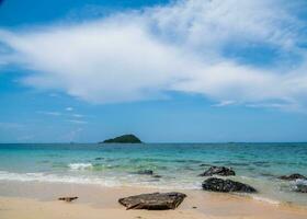 landschaft sommer vorderansicht tropisch meer strand felsen blau weiß sand hintergrund ruhig natur ozean schön welle absturz spritzwasser reise nang ram strand ostthailand chonburi exotisch horizont. foto