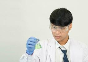 asiatisch Mann Schüler Wissenschaftler oder Arzt aussehen Hand halten im Reagens Mischen Labor im ein Wissenschaft Forschung Labor mit Prüfung Röhren von verschiedene Größen im Labor Chemie Labor Weiß Hintergrund. foto