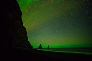 Nordlichter über dem schwarzen Sandstrand in vik foto