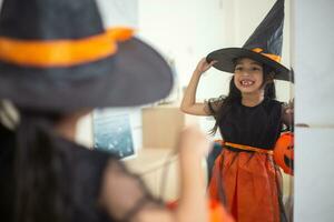 glücklich asiatisch Kind Mädchen im ein Hexe Kostüm zu Halloween. Trick oder behandeln. Kinder Trick oder behandeln. foto
