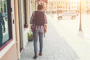 Rückseite des jungen Reisenden mit Rucksack im Abenteuerurlaub foto