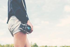 schöne Frauenfotografin stehende Hand mit Retro-Kamera foto