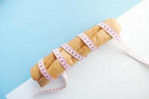 Scheibe Vollkornbrot und Maßband auf dem Tisch. foto