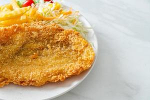 gebratenes Fischfilet und Kartoffelchips mit Minisalat foto