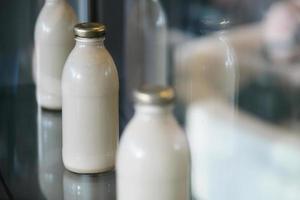 Retro-weiße Milchflaschen als Dekoration auf der Vitrine des Bioladens platziert
