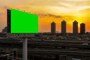 Greenscreen-Reklametafel neben der Schnellstraße bei wunderschönem Sonnenuntergang foto