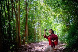 asiatischer weiblicher Hipster, der im Wald wandert foto