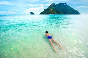 kleiner Junge schwimmen und entspannen Sie im klaren tropischen Meer? foto