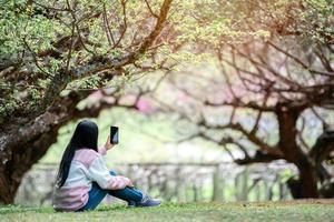 asiatische reisende macht selfie im garten foto