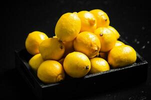frisch Zitronen. auf schwarz Tisch. foto