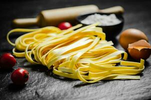 hausgemacht Pasta Tagliatelle. auf schwarz Tisch. foto