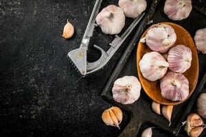 Knoblauch auf ein hölzern Teller auf ein Schneiden Tafel. foto