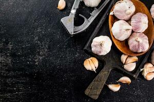 Knoblauch auf ein hölzern Teller auf ein Schneiden Tafel. foto