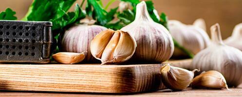 Knoblauch mit Petersilie auf ein hölzern Schneiden Tafel. foto