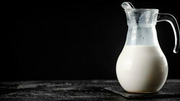 Milch im ein Krug auf das Tisch. foto