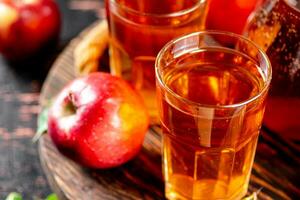 Apfel Saft auf ein hölzern Tablett. foto