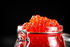 ein öffnen Glas Krug voll von rot Kaviar. foto