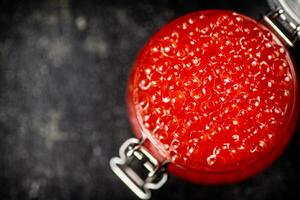 ein öffnen Glas Krug mit rot Kaviar auf das Tisch. foto