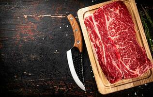 roh Rindfleisch auf ein hölzern Schneiden Tafel mit Rosmarin. foto