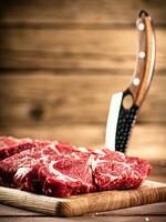 roh Rindfleisch auf ein Schneiden Tafel mit ein Messer. foto
