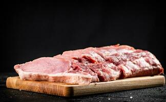 roh Schweinefleisch geschnitten auf ein hölzern Schneiden Tafel. foto