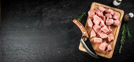 gehackt roh Schweinefleisch auf ein Schneiden Tafel mit Messer, Gewürze und Rosmarin. foto