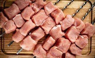 Schweinefleisch roh Kebab auf ein Schneiden Tafel. foto