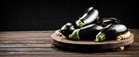 reif Aubergine auf ein hölzern Tablett. foto