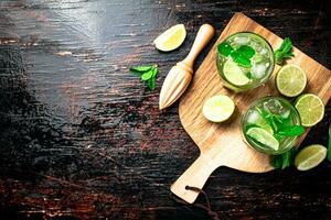 Mojito mit Stücke von Limette auf ein Schneiden Tafel. foto