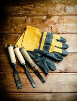 Meißel mit Konstruktion Handschuhe auf das Tisch. foto