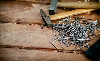 Hammer mit ein Bündel von Nägel auf das Tisch. foto