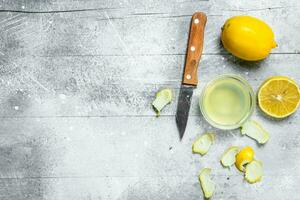 Zitrone Saft Schüssel mit das Zitrusschale von ein Zitrone und ein Messer. foto