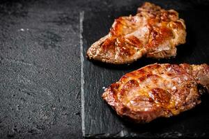 köstlich gegrillt Schweinefleisch Steak auf ein Stein Tafel. foto