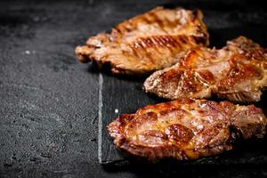 köstlich gegrillt Schweinefleisch Steak auf ein Stein Tafel. foto