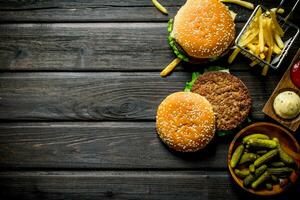 Burger mit Essiggurken im Schüssel, französisch Fritten und Saucen. foto