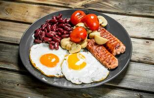 Englisch Frühstück.gebraten Eier mit Würste, Pilze und Bohnen. foto