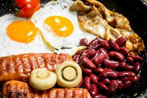 Englisch Frühstück.gebraten Eier mit Würste, Pilze und Bohnen. foto